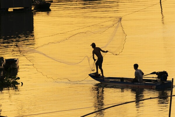 Personas Lanzando una red de pesca.